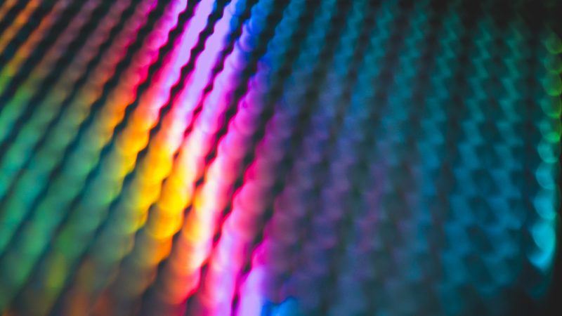 Abstract and pattern background in intense rainbow light colors in contrast with a black background